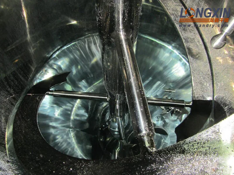 View into a conical vacuum dryer showing the central shaft and heated helical agitator