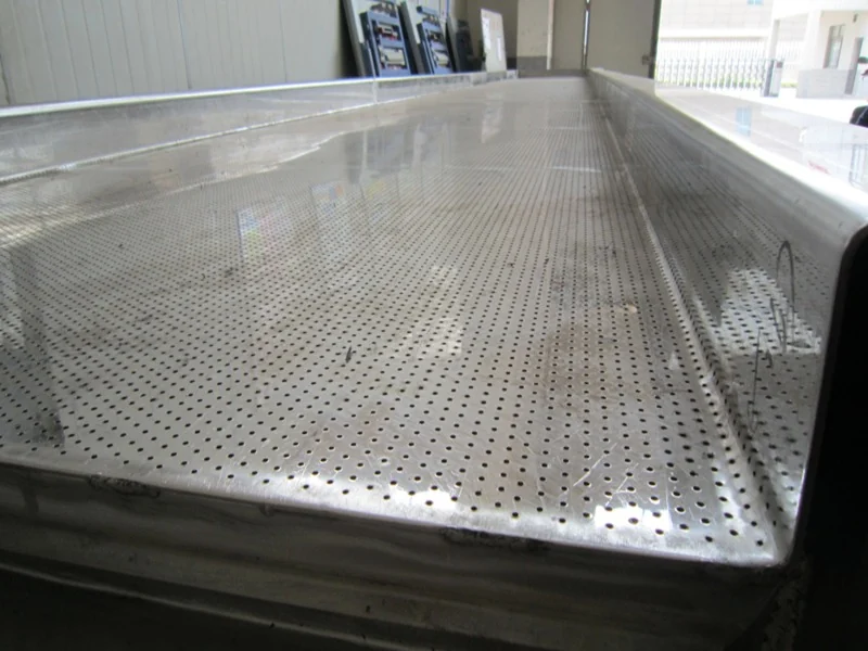 Close-up of the perforated bed plate at the discharge end of a vibrating fluid bed