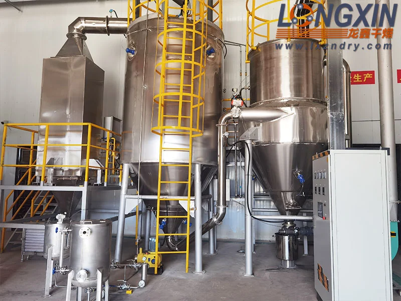 QPG fluid nozzle spray dryer with stainless steel drying chamber and access platform.